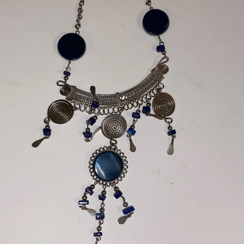 Ornate Silver-Toned Necklace with a Curved Center Adorned with Blue/Black Stones